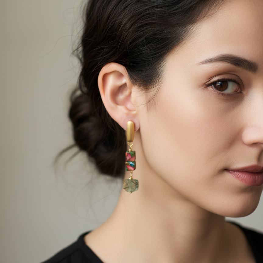 Woman wearing gold and gemstone earrings on ears