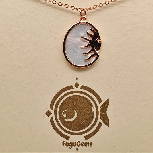 Close-up of oval pendant and sun face engraving on Fugugemz branding