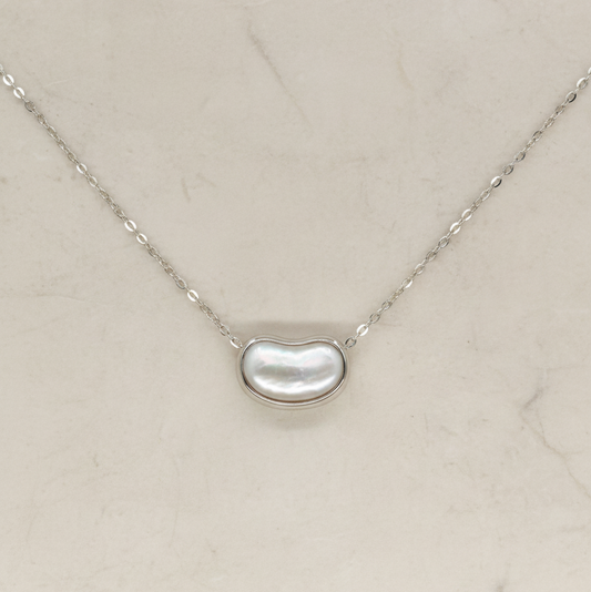 Necklace with a kidney-shaped pearl pendant on a light beige background