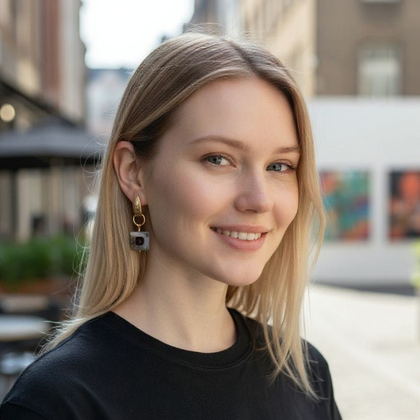 Woman wearing gold-plated agate and garnet earrings with wavy hair