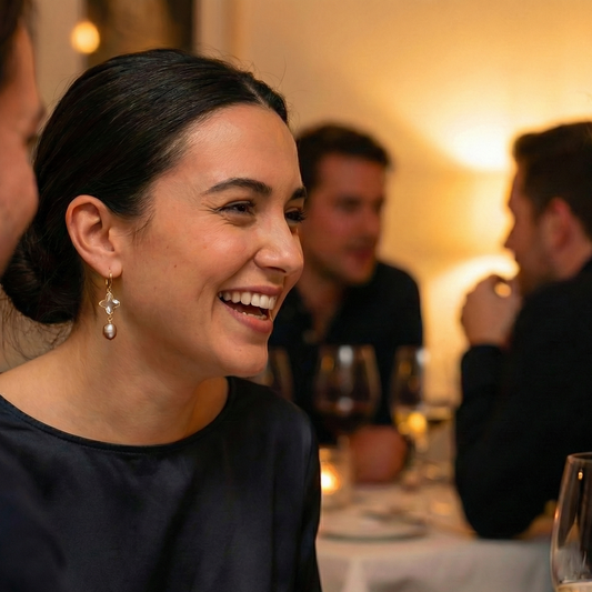Woman wearing gold-plated star and pearl hoop earrings