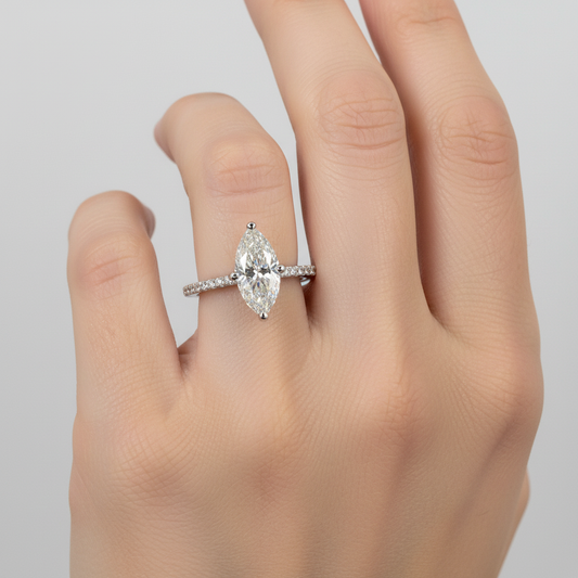 maisonette ring on a finger against a neutral background