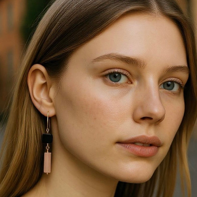 Woman wearing black agate and pink quartz drop earrings with soft waves