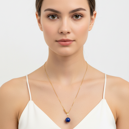 Woman wearing a gold necklace with a blue pendant on a white background