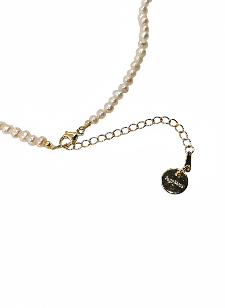 Pearl necklace with a gold chain and tag on a white background