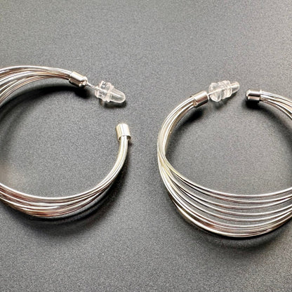 Pair of silver hoop earrings on a gray background