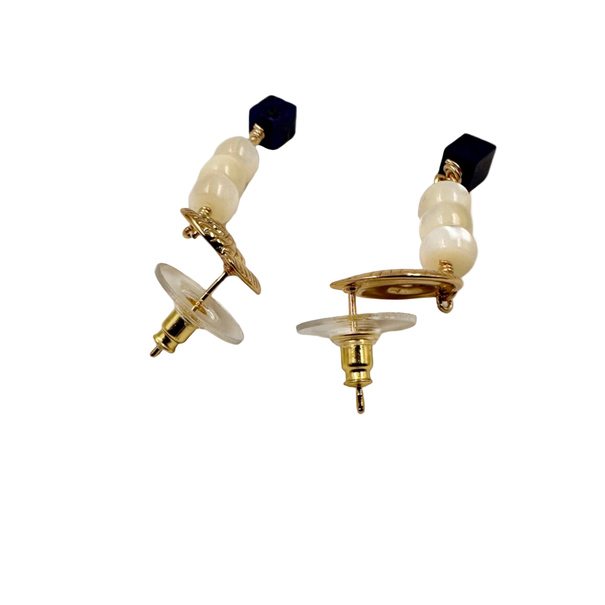 Pair of earrings with pearls and black beads on a white background