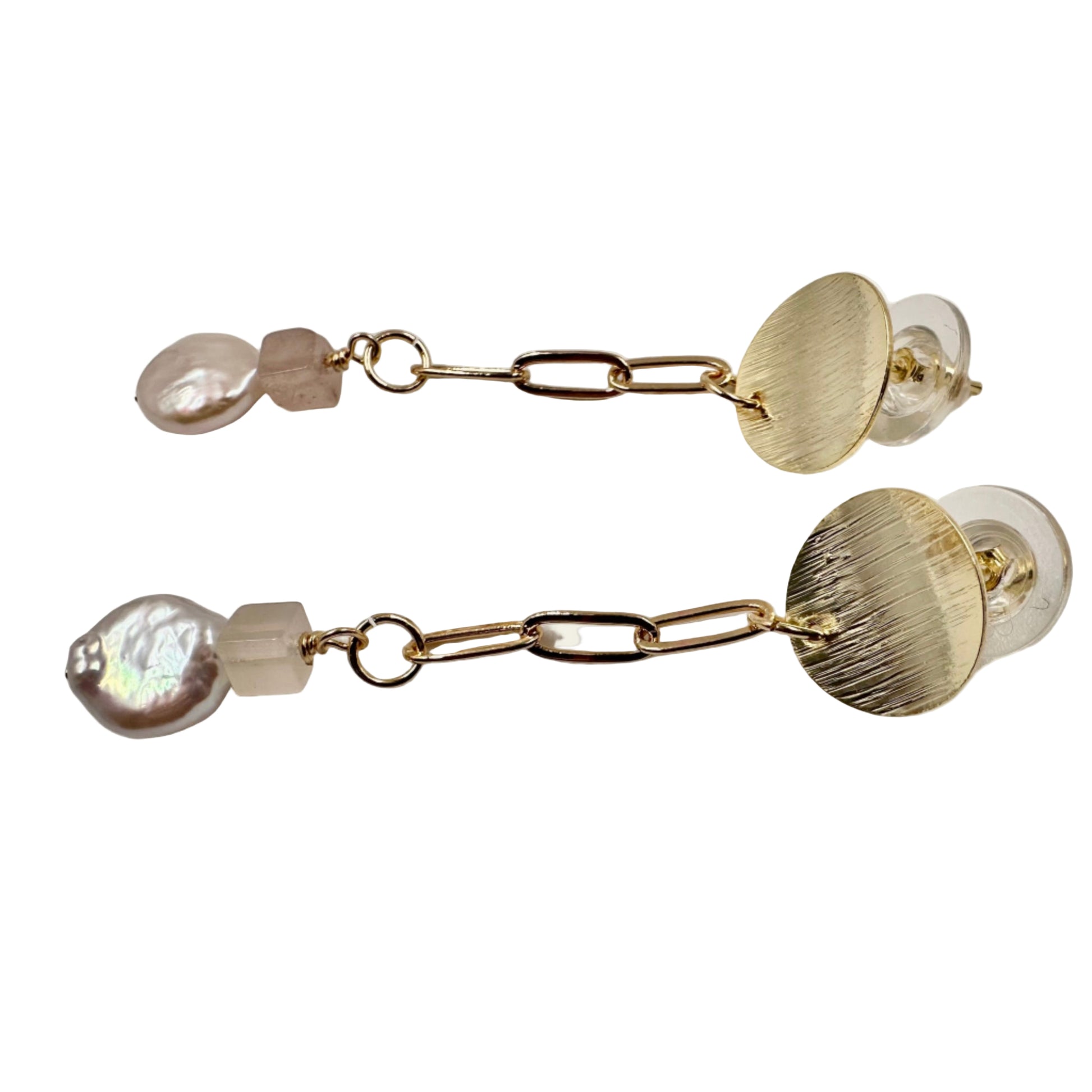 Close-up of textured disc, pink quartz, and baroque pearl details
