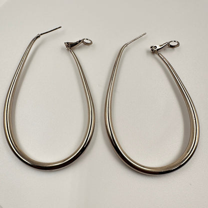 Pair of silver hoop earrings on a white plate