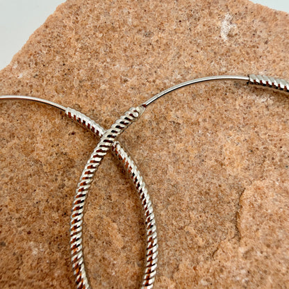 Close-up of twisted rope pattern and endless closure on 40mm silver hoop earrings with 925 stamp
