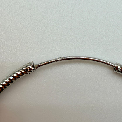Close-up of twisted rope pattern and snap closure on 40mm silver hoop earrings with 925 stamp
