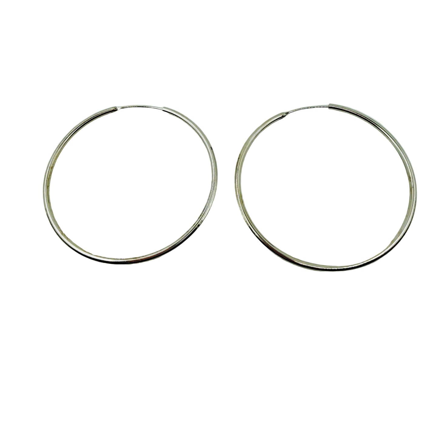 Pair of 55mm silver hoop earrings on a light gray background