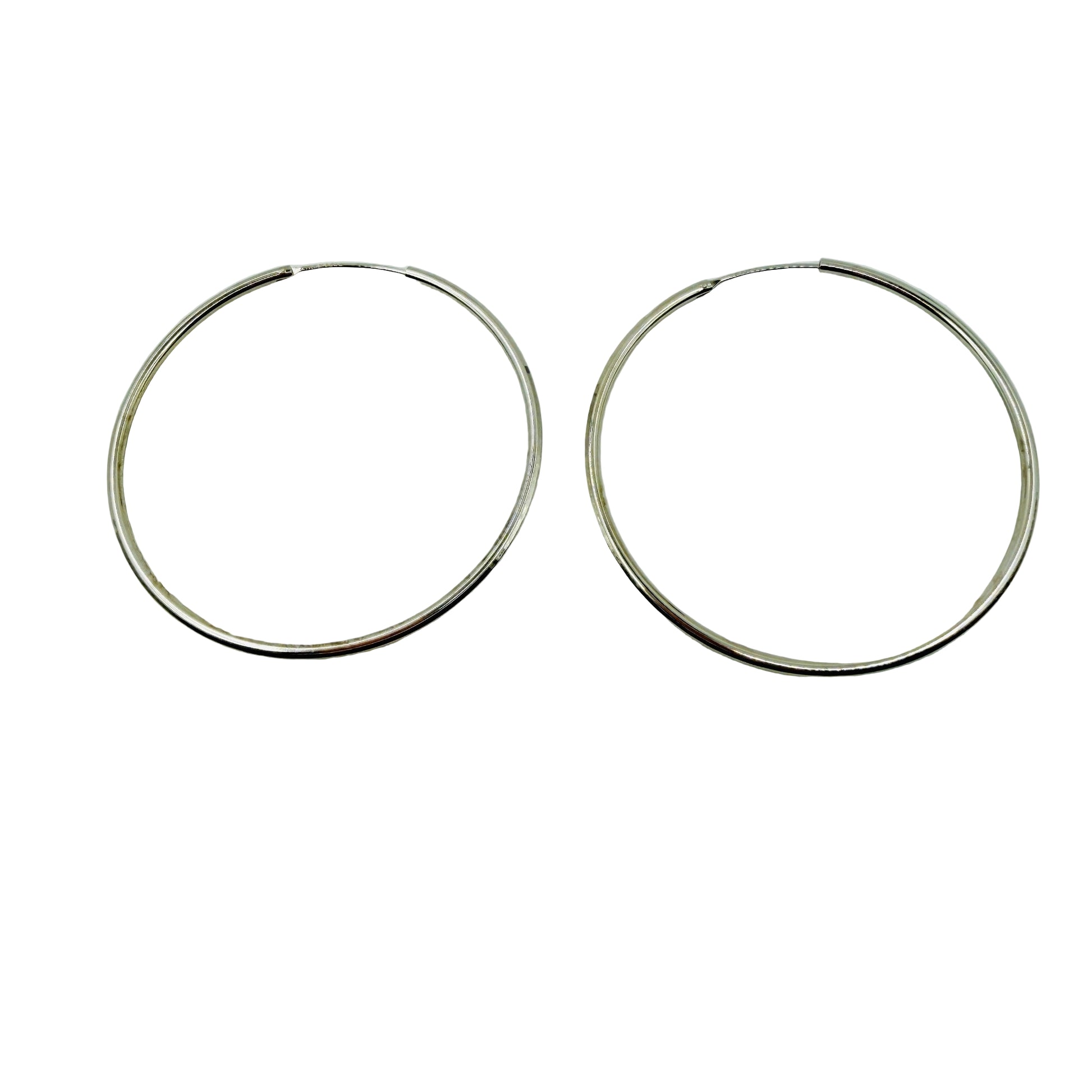 Pair of 55mm silver hoop earrings on a light gray background