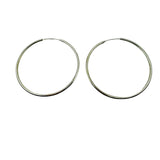 Pair of 55mm silver hoop earrings on a light gray background