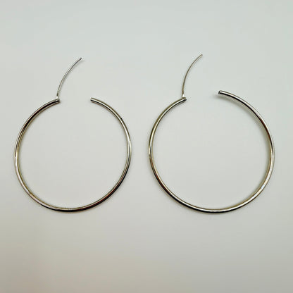 Pair of silver hoop earrings on a light gray background