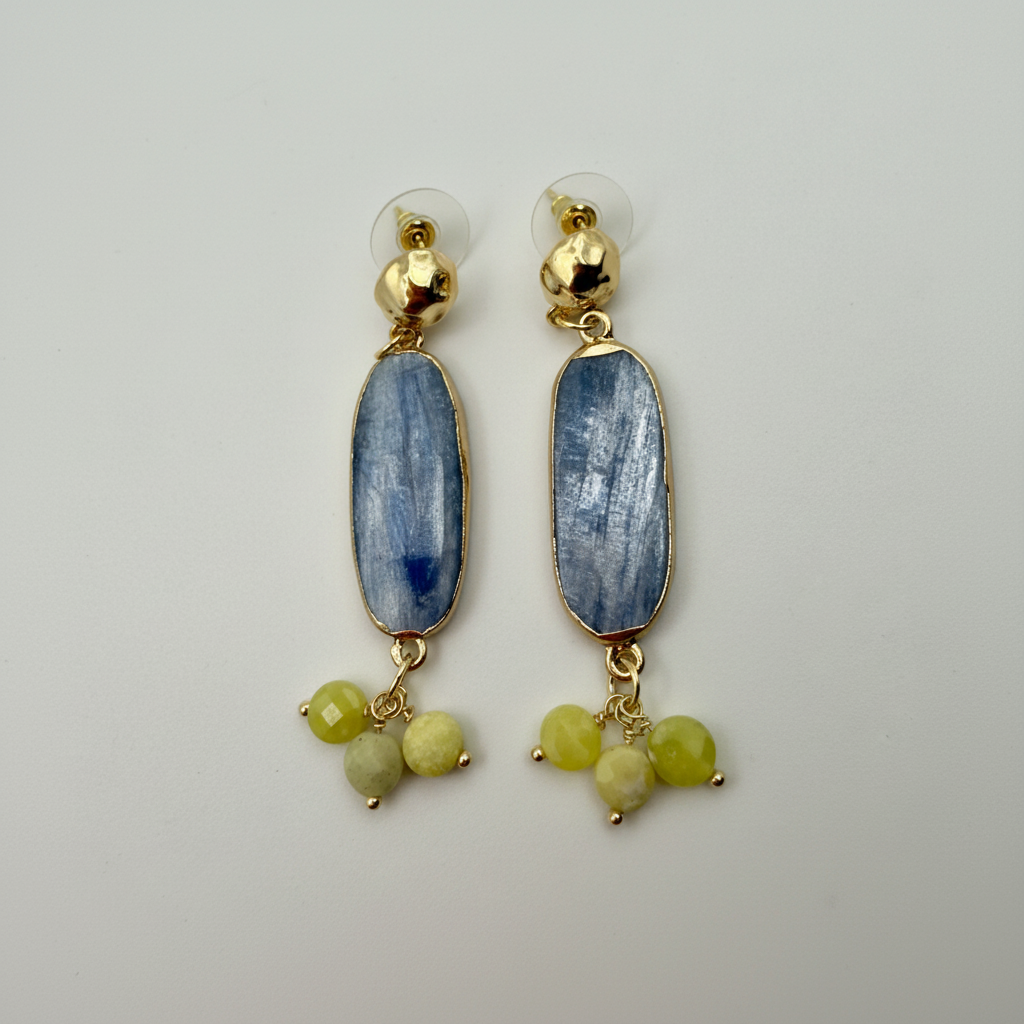 Pair of earrings with blue stones and gold accents on a light gray background