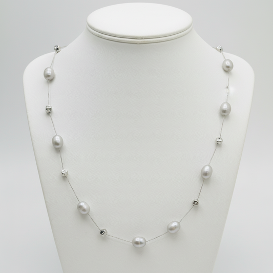 Pearl necklace on a mannequin bust against a white background