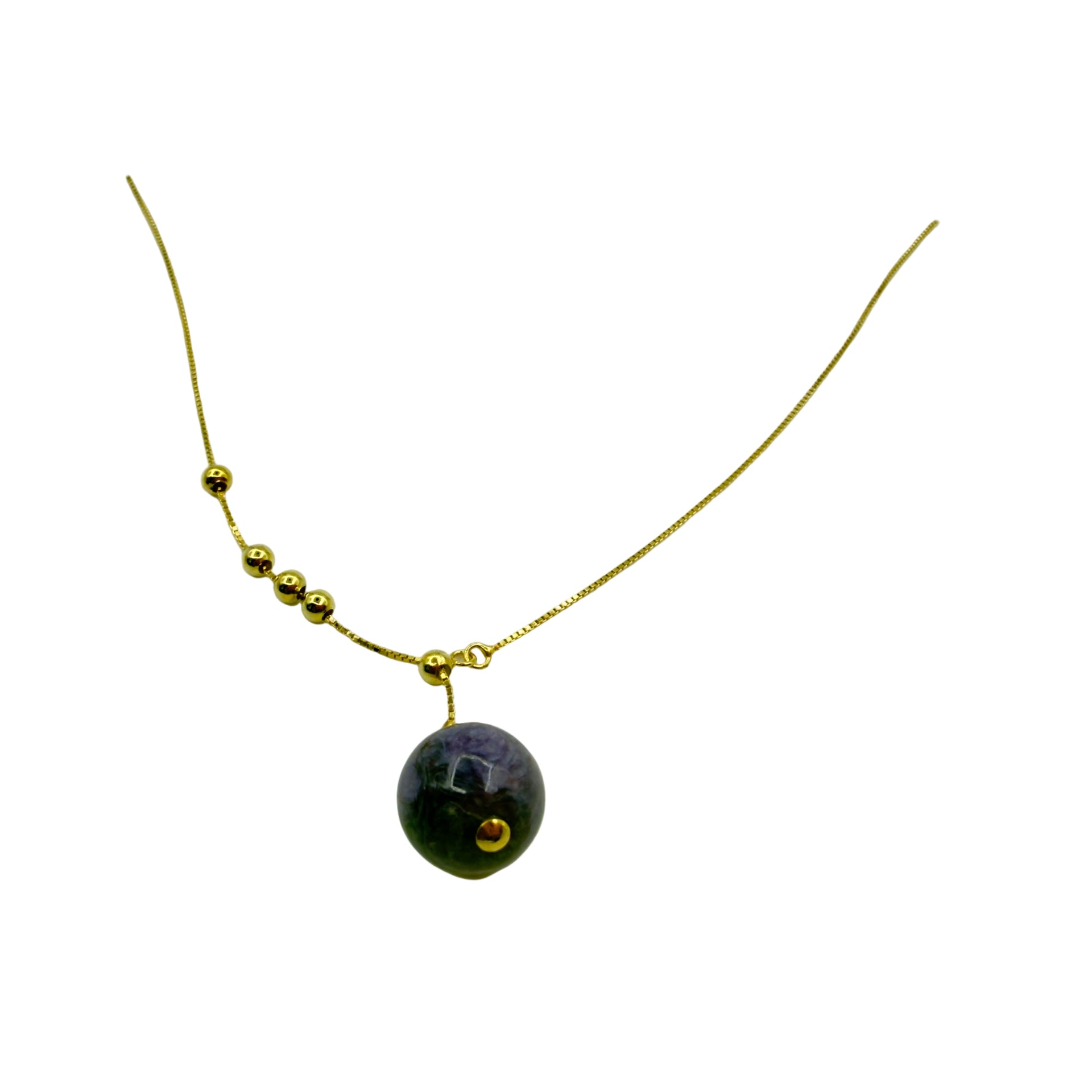 Gold necklace with a dark purple pendant on a white background