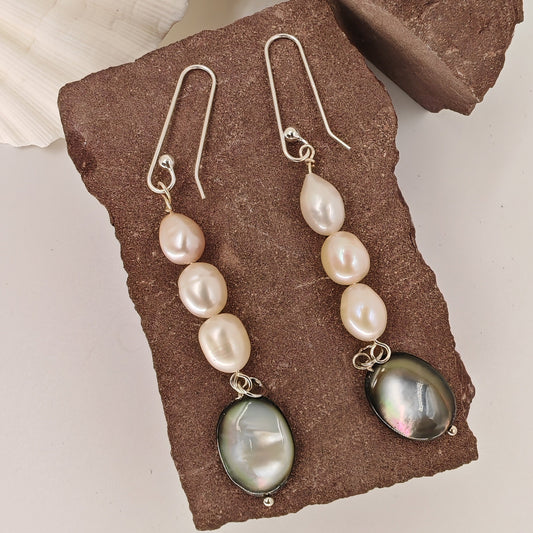 Three baroque freshwater pearls cascading into a black shell pendant