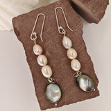 Three baroque freshwater pearls cascading into a black shell pendant