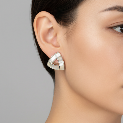 Woman wearing triangle shell stud earrings with wavy hair and neutral makeup