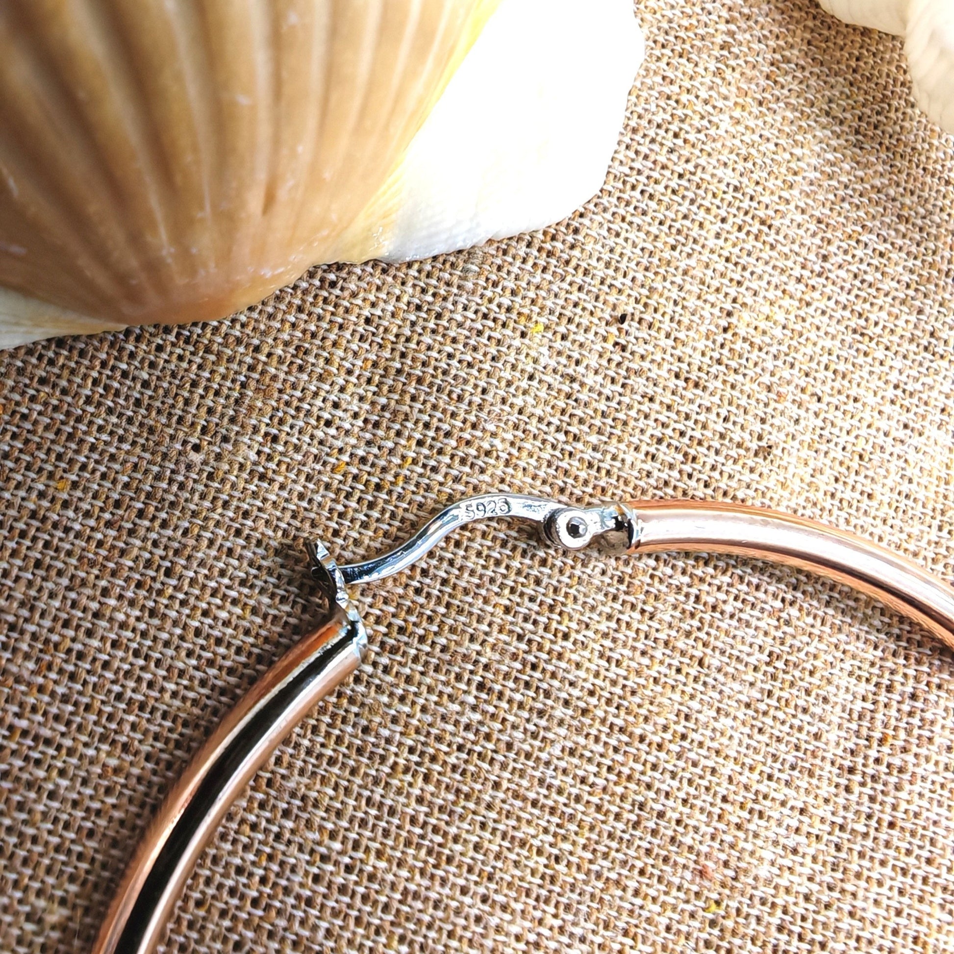 Close-up of copper-plated surface and "S925" hallmark on sterling silver clasp