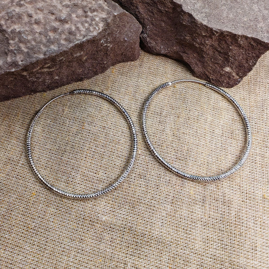 40mm sterling silver twisted rope hoop earrings on burlap background with rocks