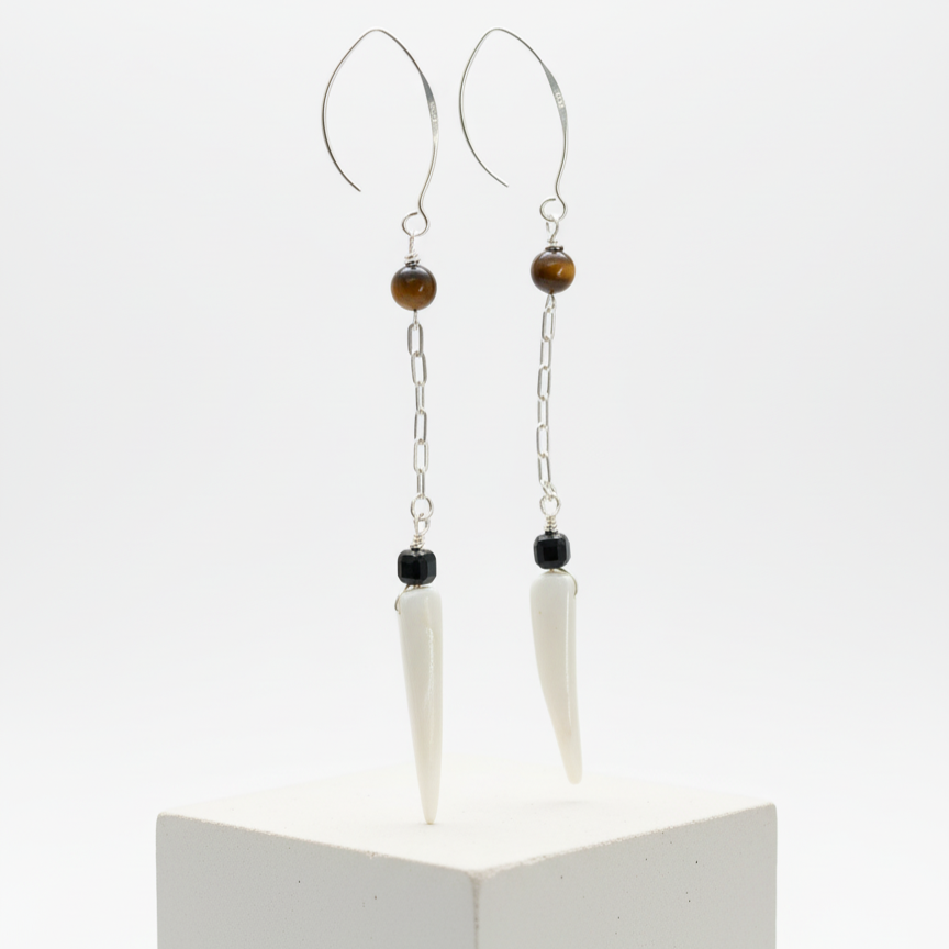 Close-up of tiger eye, black agate, and shell tiger tooth bead