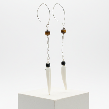 Close-up of tiger eye, black agate, and shell tiger tooth bead