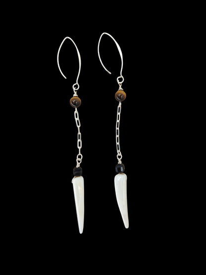 Close-up of tiger eye, black agate, and shell tiger tooth bead