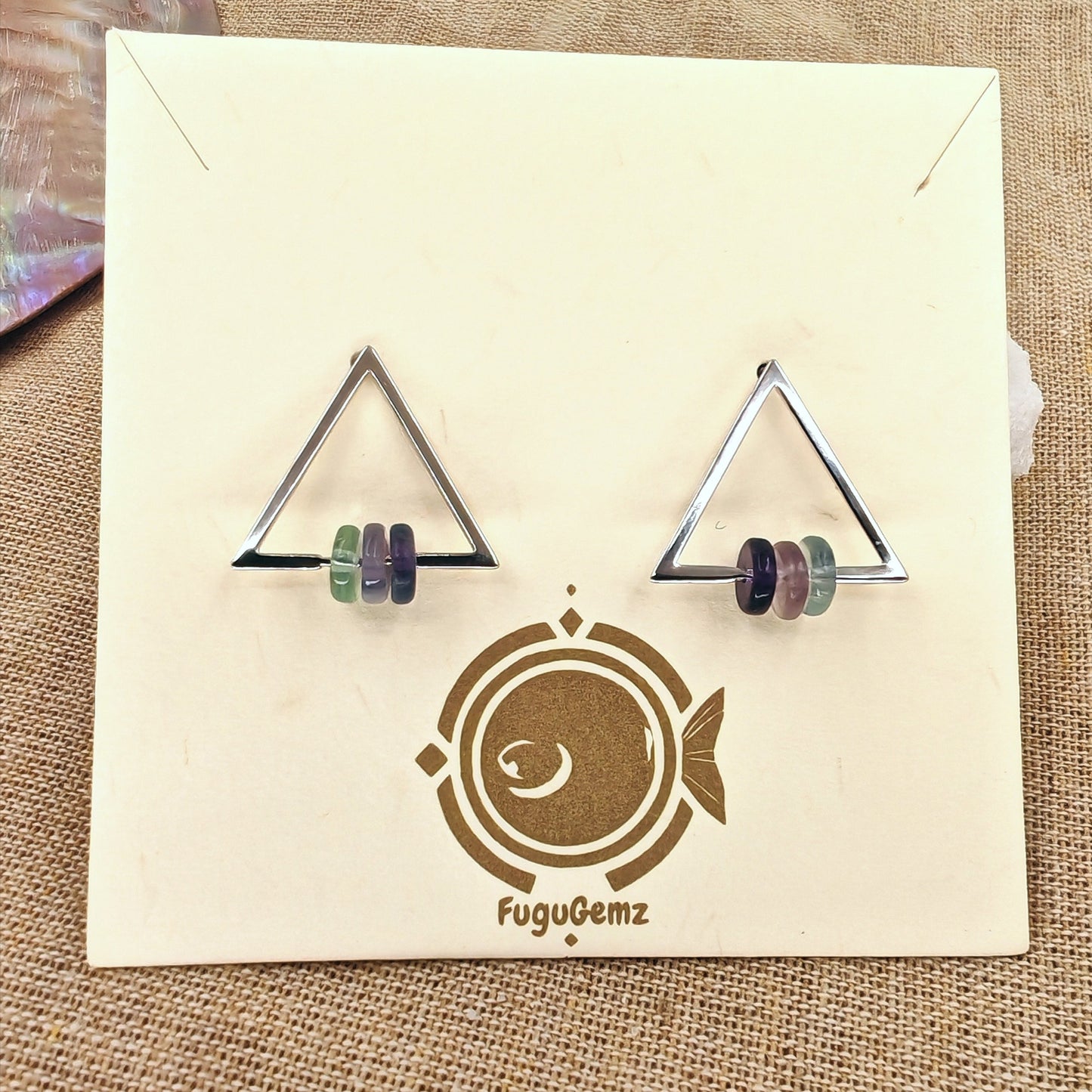 Triangular earrings on a FuguGemz branded card with a textured background