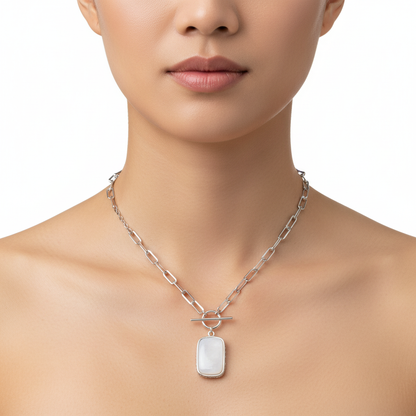 Silver necklace with a pendant on a model against a white background