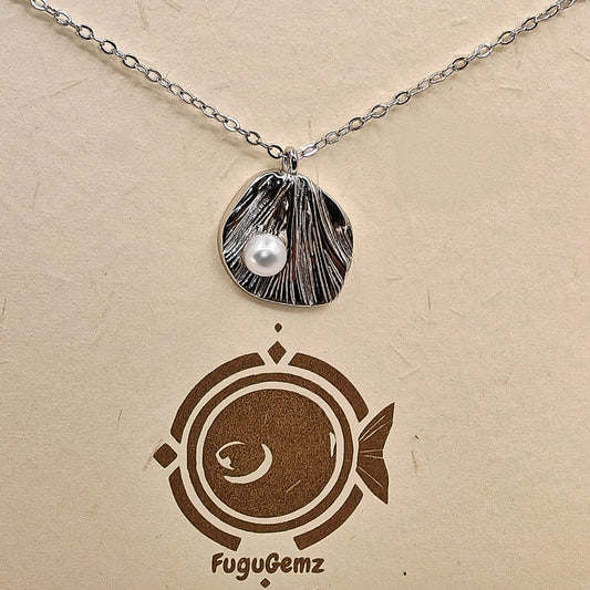 Close-up of textured silver leaf and pearl with Fugugemz branding