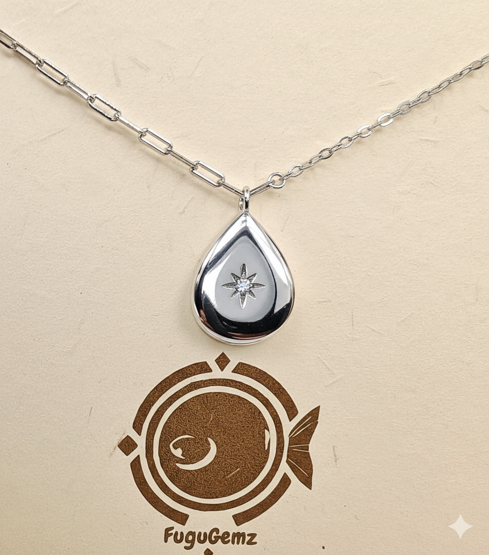 Necklace with a black teardrop pendant featuring a star design, on a beige background with FuguGemz logo.