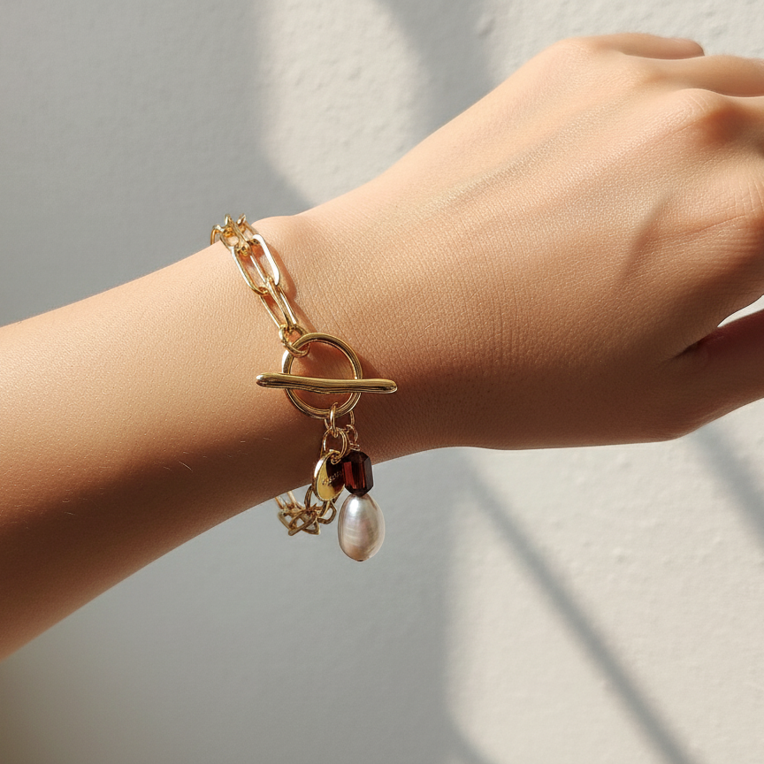 Woman wearing gold, pearl, and garnet bracelet on wrist

