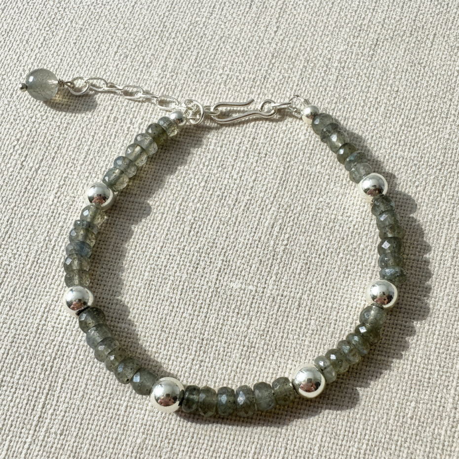 17cm labradorite bracelet with 42x4.5mm faceted beads and 6x5.8mm 925 plated beads on beige background