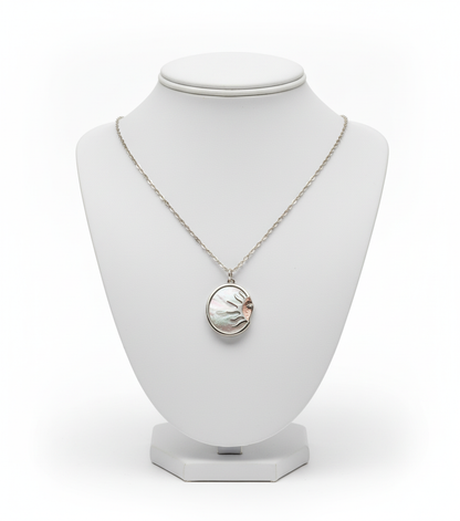 Necklace with a circular pendant on a white mannequin bust against a white background
