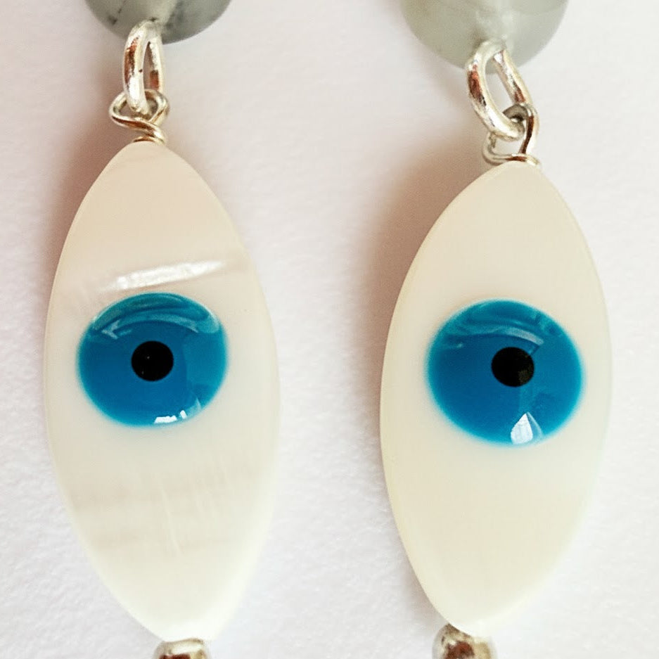 Eyeball-shaped earrings with blue pupils on a white background