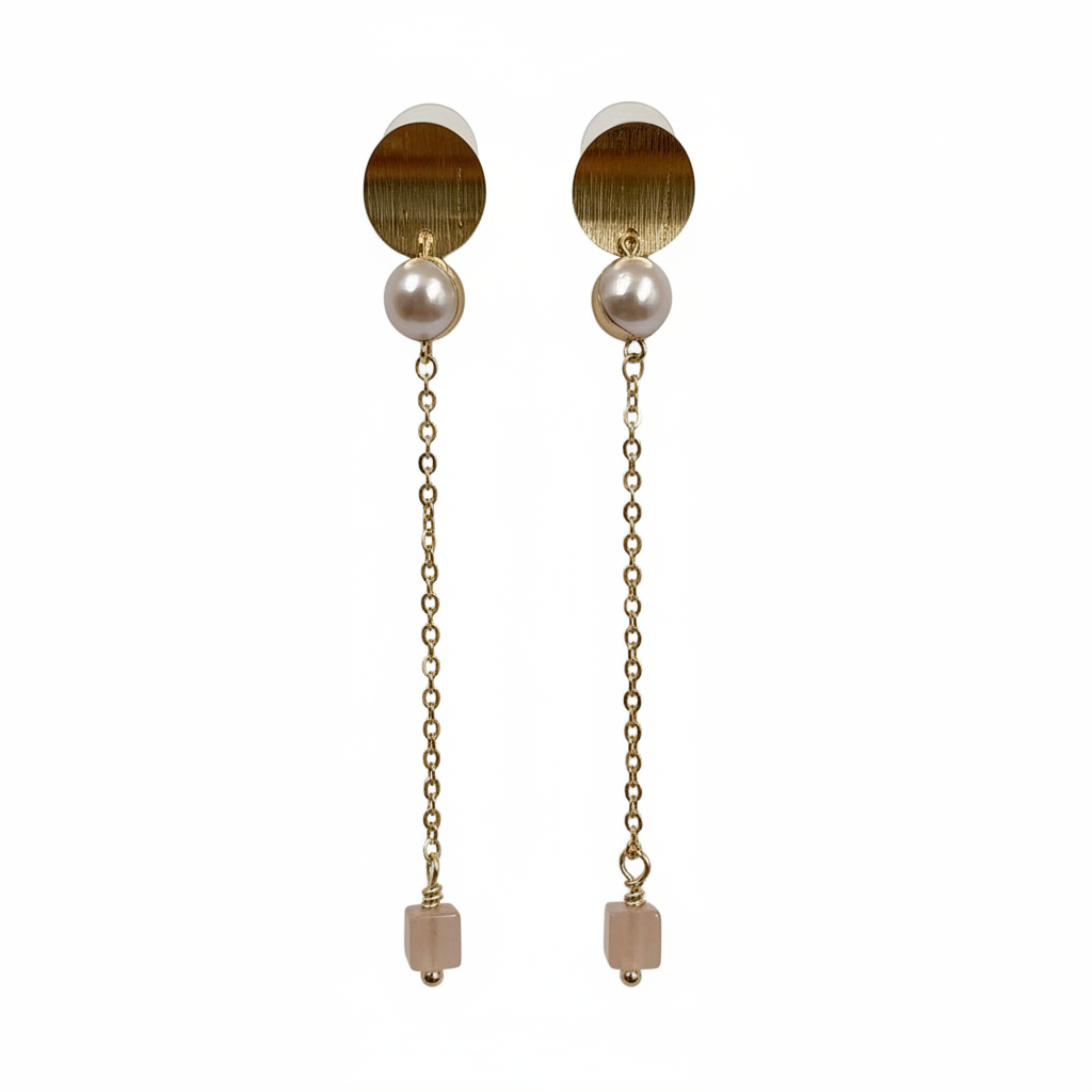 Pair of earrings with gold and pearl elements on a white background