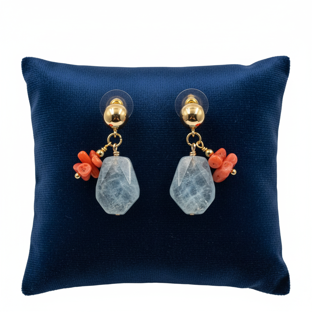 Pair of earrings with coral and gemstone drops on a blue cushion