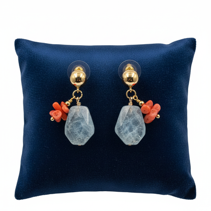 Pair of earrings with coral and gemstone drops on a blue cushion