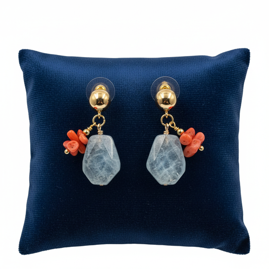 Pair of earrings with coral and gemstone drops on a blue cushion