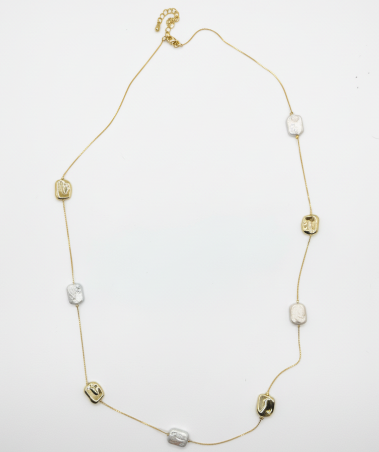 Gold necklace with various beads on a white background