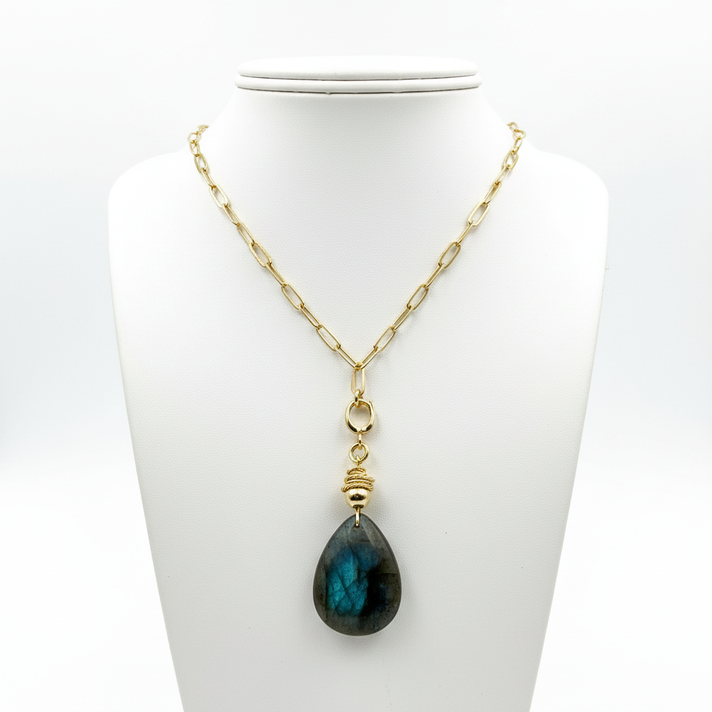 Necklace with a blue teardrop pendant on a white stand