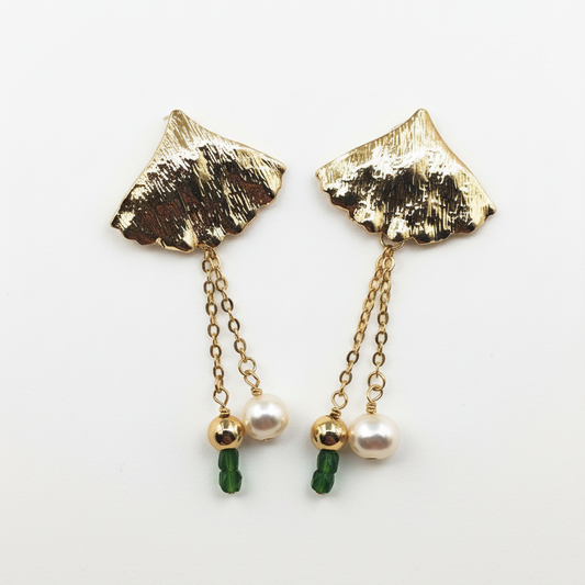 Gold leaf-shaped earrings with green beads and pearls on a white background