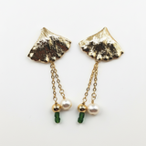 Gold leaf-shaped earrings with green beads and pearls on a white background