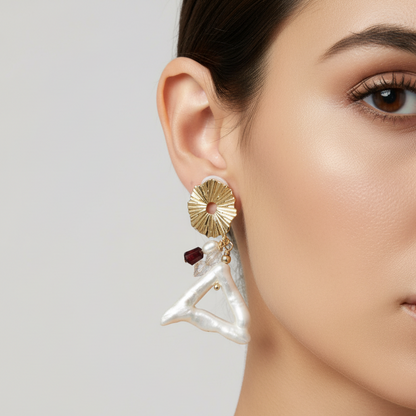 Close-up of a woman wearing a gold and pearl earring on a plain background
