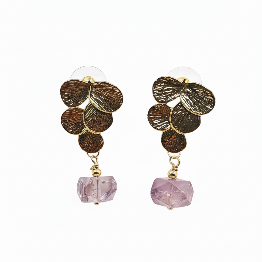 Pair of earrings with gold leaf design and pink beads on a white background